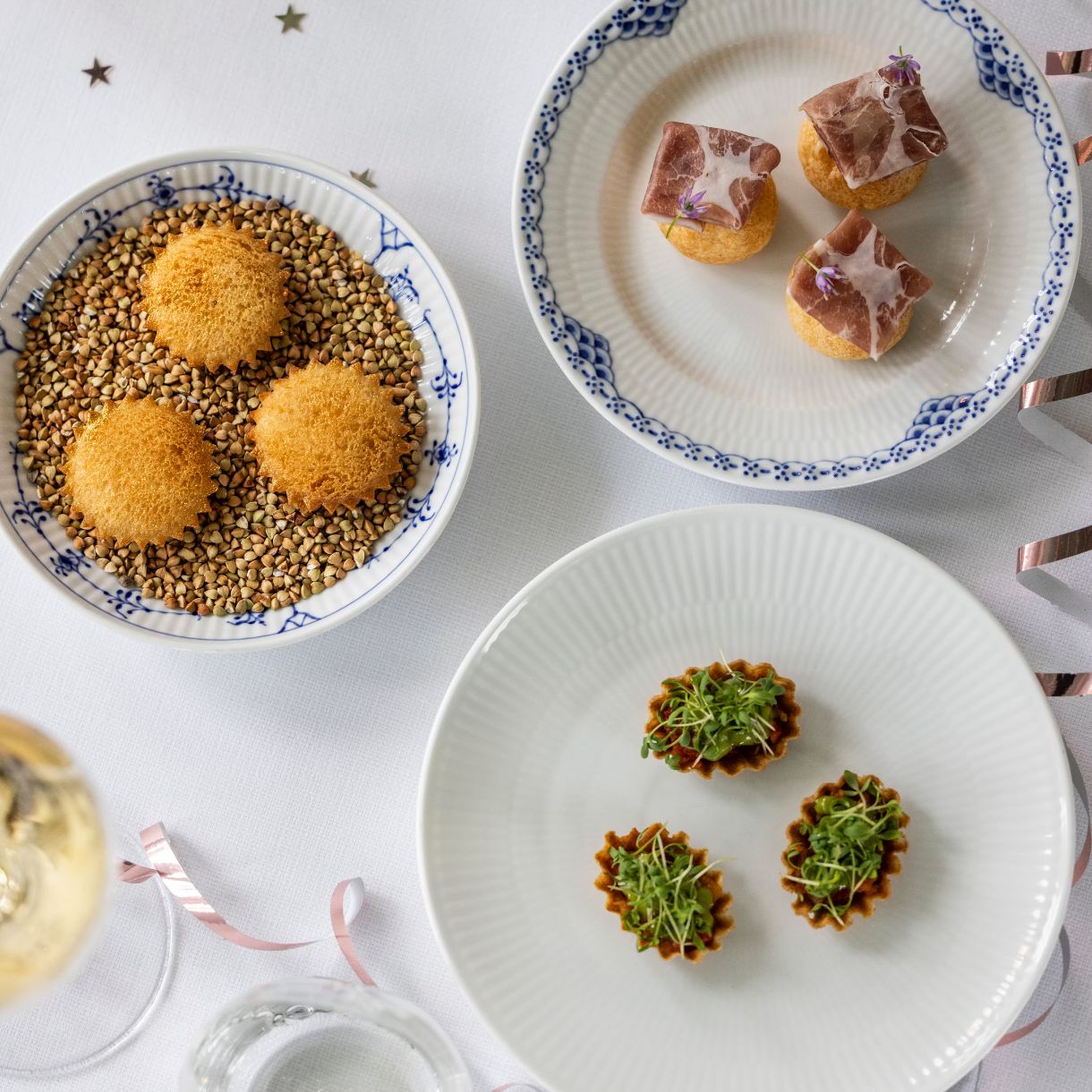 Snacks anrettet på nytårsbord med skåle og pynt.
