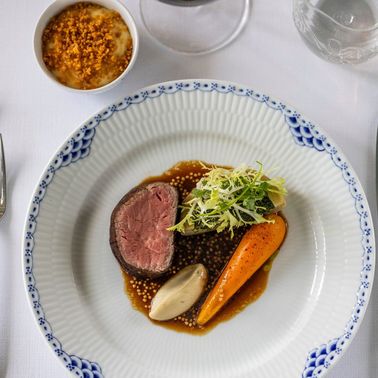 Anretning med stegt dansk oksemørbrad, syltet gulerod & artiskok, chimchurri på danske krydderurter, kartoffel & pebersauce.